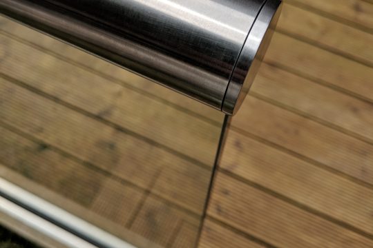 aluminox Slotted end cap on slotted handrail installed ontop a glass balustrade on decking